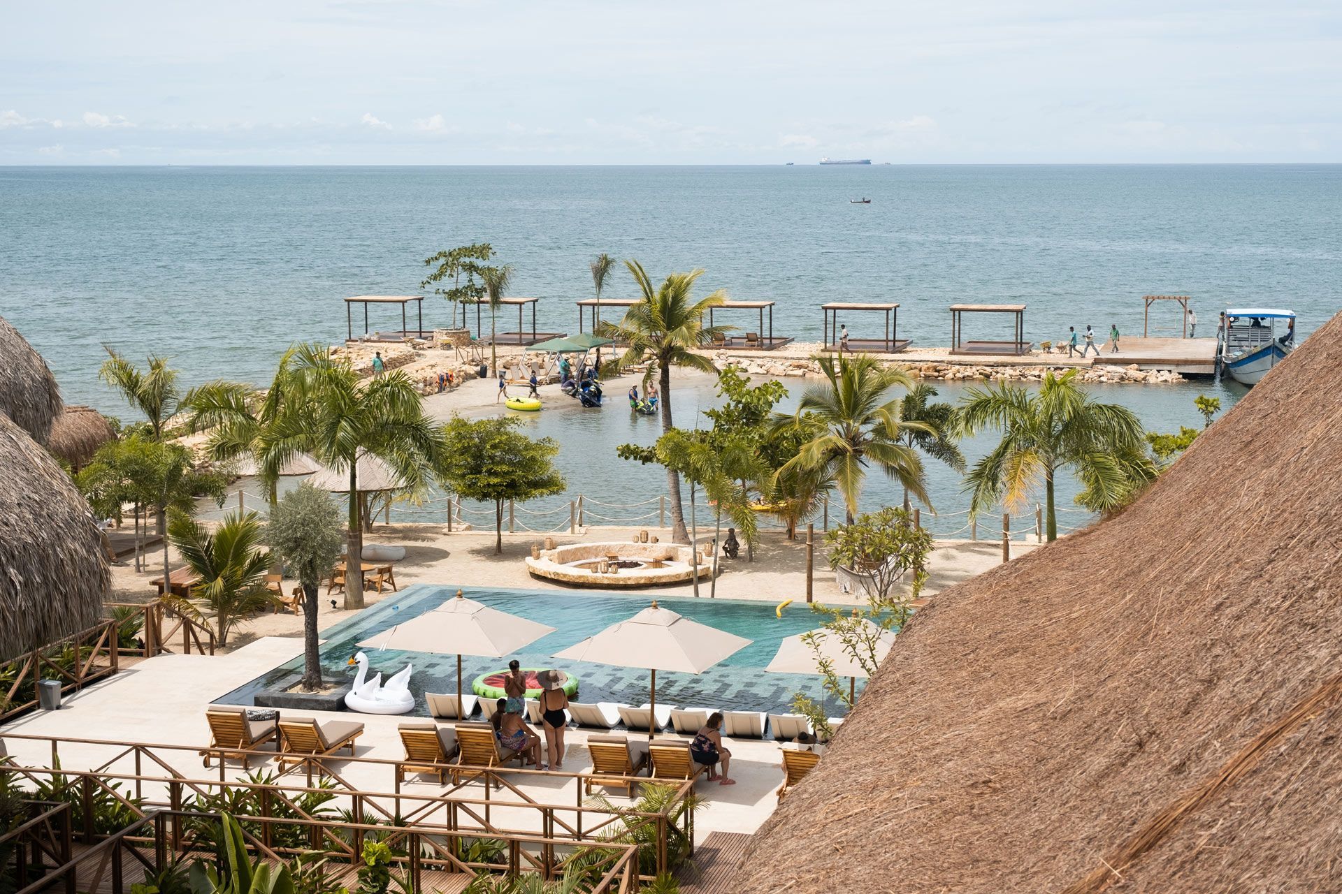 Vista aérea do Hotel Aimarawa em San Antero, com piscina, praia, palmeiras e áreas de descanso.