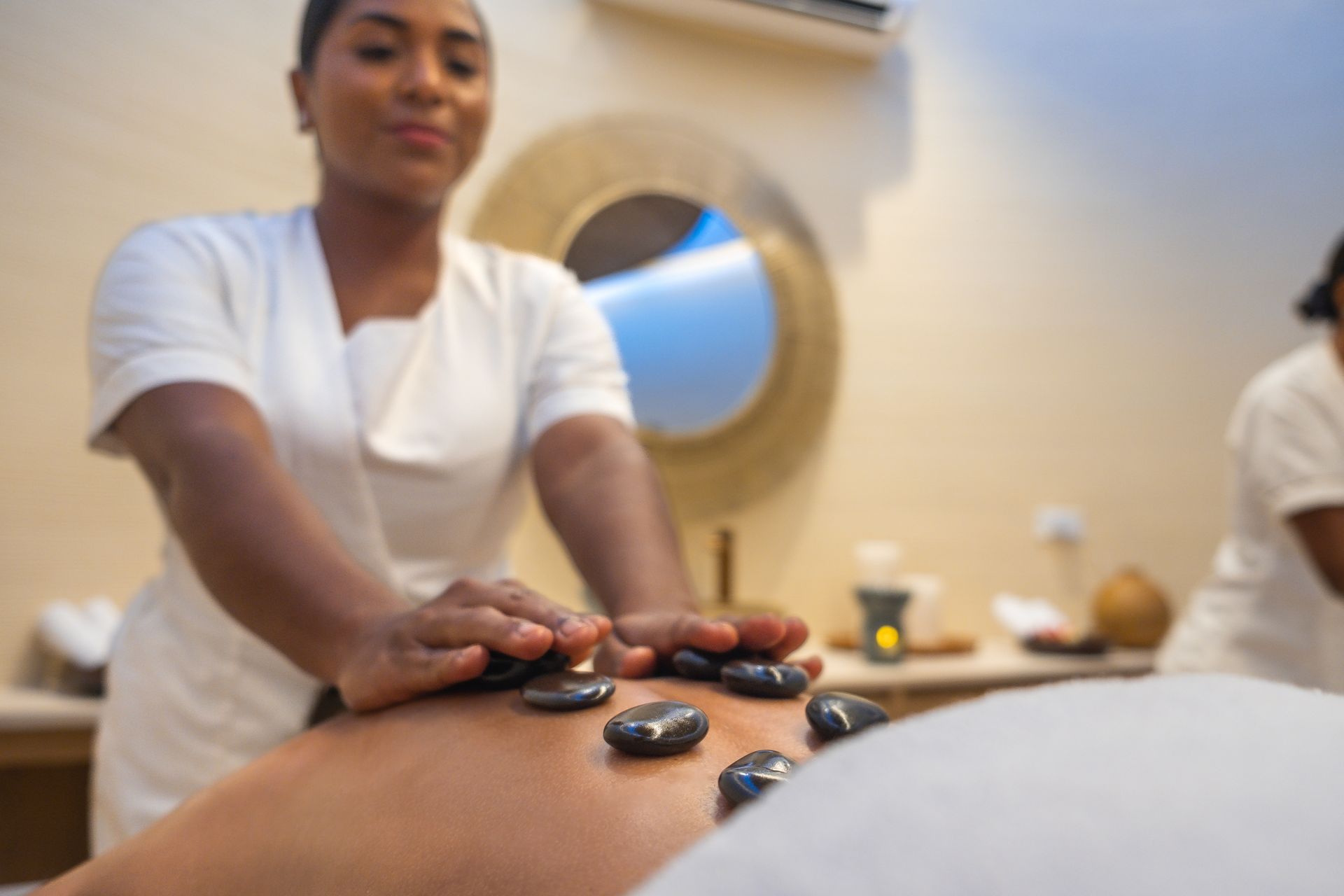 Hot stone treatment at Aimarawa spa, a wellness experience at a hotel in San Antero, Colombia.