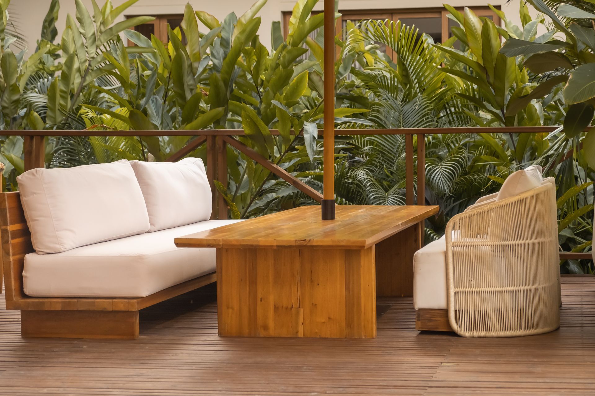 Lounge terrace at Hotel Aimarawa with cushioned sofas, wooden table, handmade chairs, and nature views.