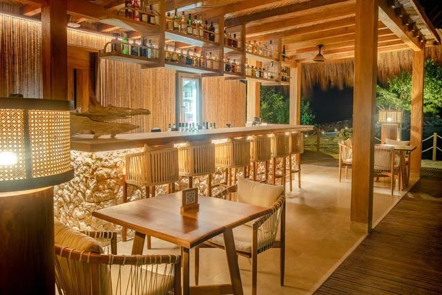 Hotel en san antero con cama amplia, cabecero de madera, decoración artesanal y luz cálida.