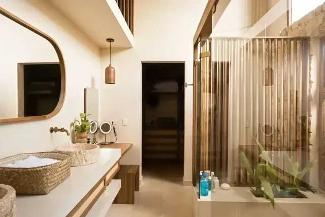 Baño de lujo en Aimarawa Punta Bolívar con diseño en madera y piedra, alojamiento sostenible y exclusivo frente al mar