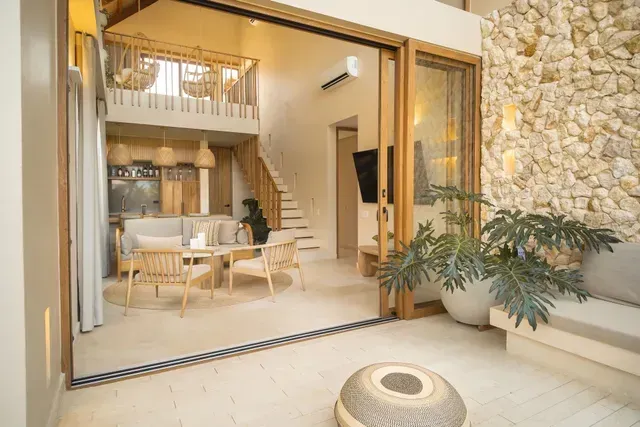 Cabanas em San Antero Córdoba no Hotel Aimarawa, com sala aberta, escada, parede de pedra e plantas.