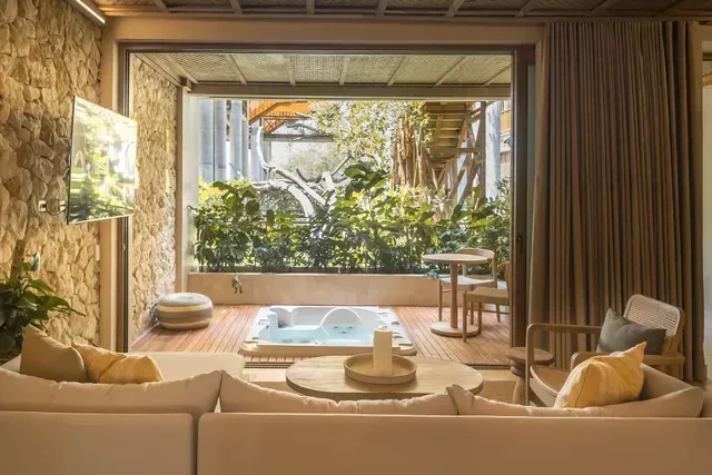 Suite en Aimarawa, hoteles en san antero, con sala y terraza con jacuzzi entre vegetación.