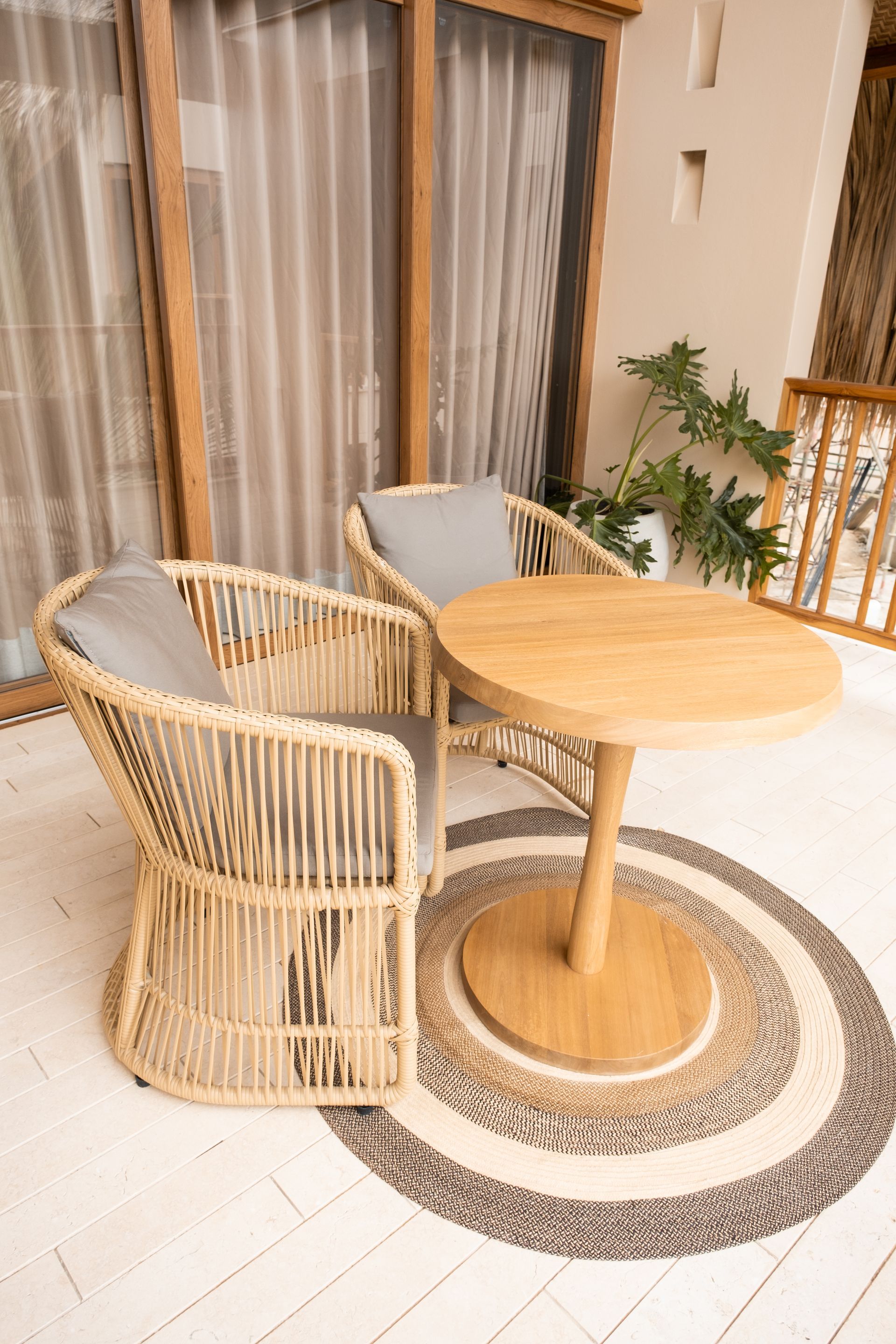 Accommodation in San Antero, Colombia, with terrace, woven chair, light curtains, and wooden railing.