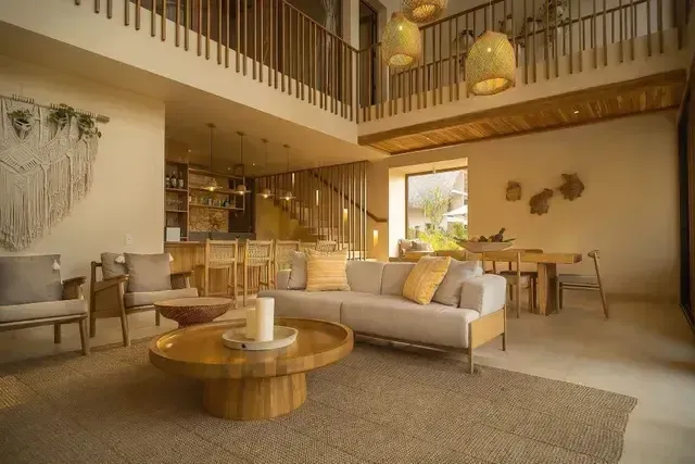 Bungalow en el Hotel Aimarawa con dos pisos, muebles en madera y fibras naturales, lámparas artesanales y comedor integrado.