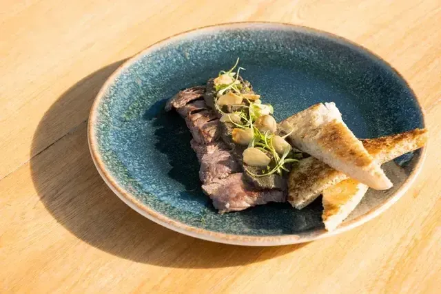 Entrada de carne sellada con champiñones y pan artesanal en restaurante del Hotel Aimarawa Punta Bolívar.