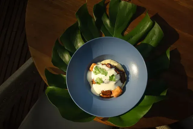 Plato servido sobre hoja tropical en Aimarawa, con presentación de comida del Caribe colombiano.
