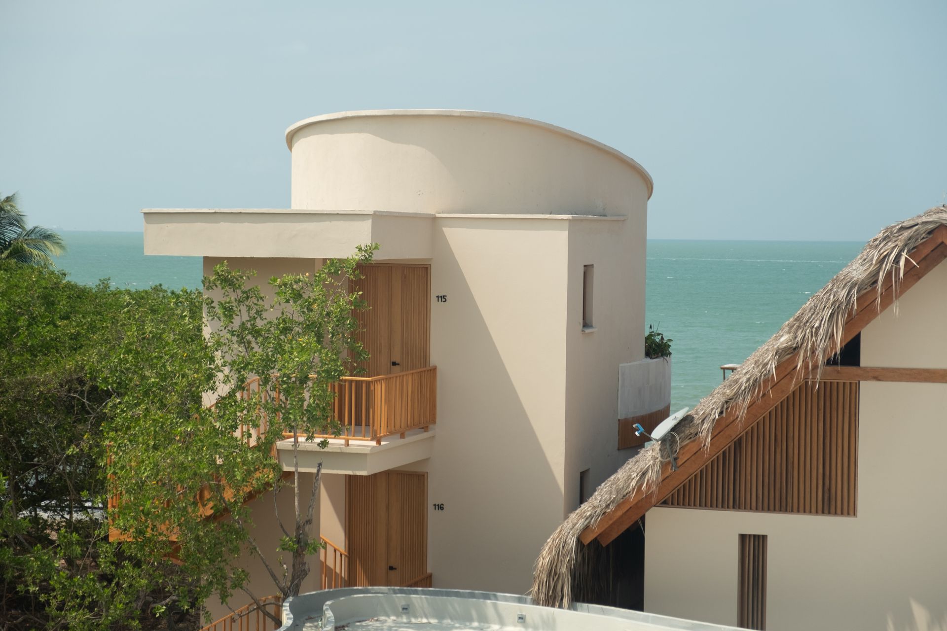 Beachfront hotel in San Antero with curved cabins, thatched roofs, and wooden balconies.