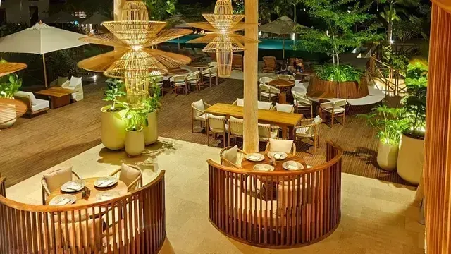 restaurante en san antero del Hotel Aimarawa con mesas circulares, lámparas artesanales y vegetación tropical.