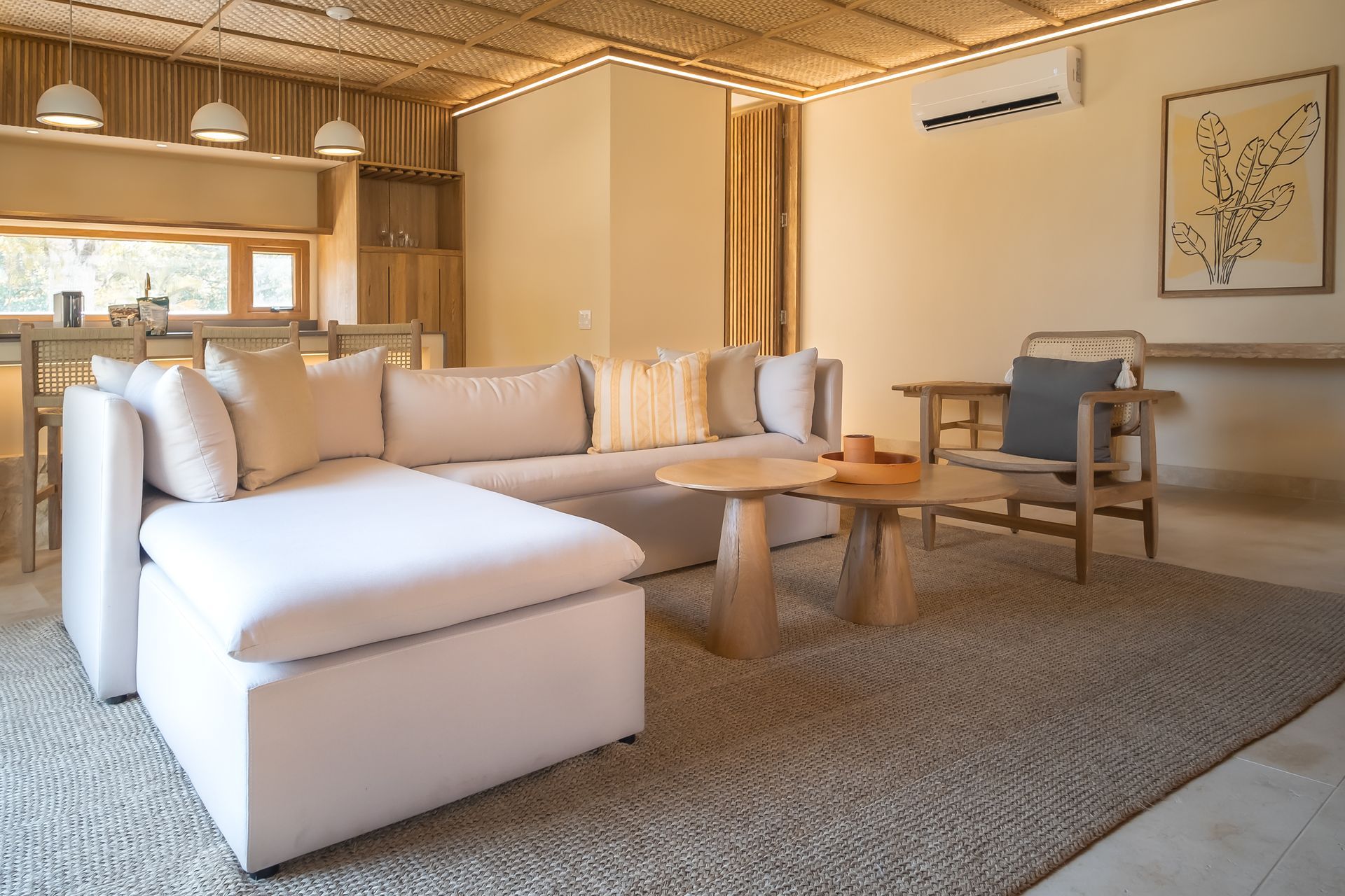 Hotels in Córdoba, Colombia with a bright living room, large sofa, wooden table, woven ceiling, and kitchen.