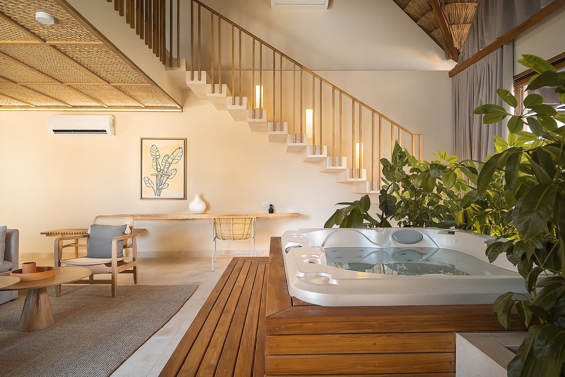 Hotel in San Antero, Colombia, with indoor tub, staircase, plants, and a wooden lounge area.