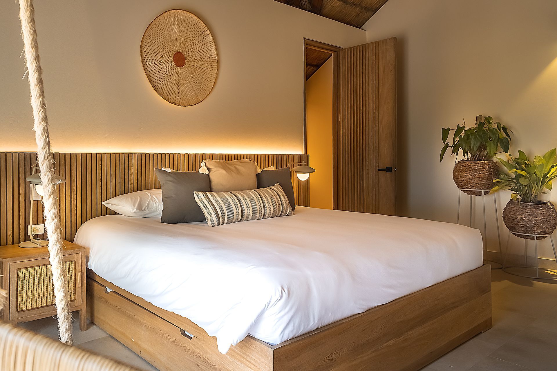 Hotels in San Antero, Colombia, with a spacious bed, warm lighting, wood accents, and handmade décor.
