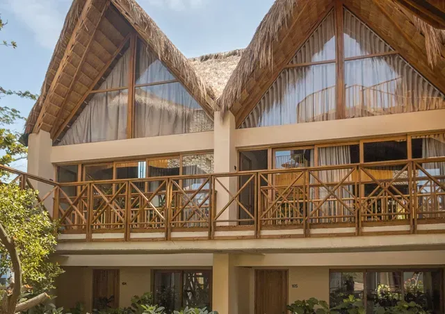 Fachada de Aimarawa, hoteles en san antero, con balcones de madera, techos de palma y arquitectura tropical.