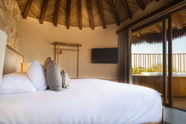 cabañas en san antero córdoba con cama tipo king, techo de palma, ventanal y balcón de madera con vista a la naturaleza