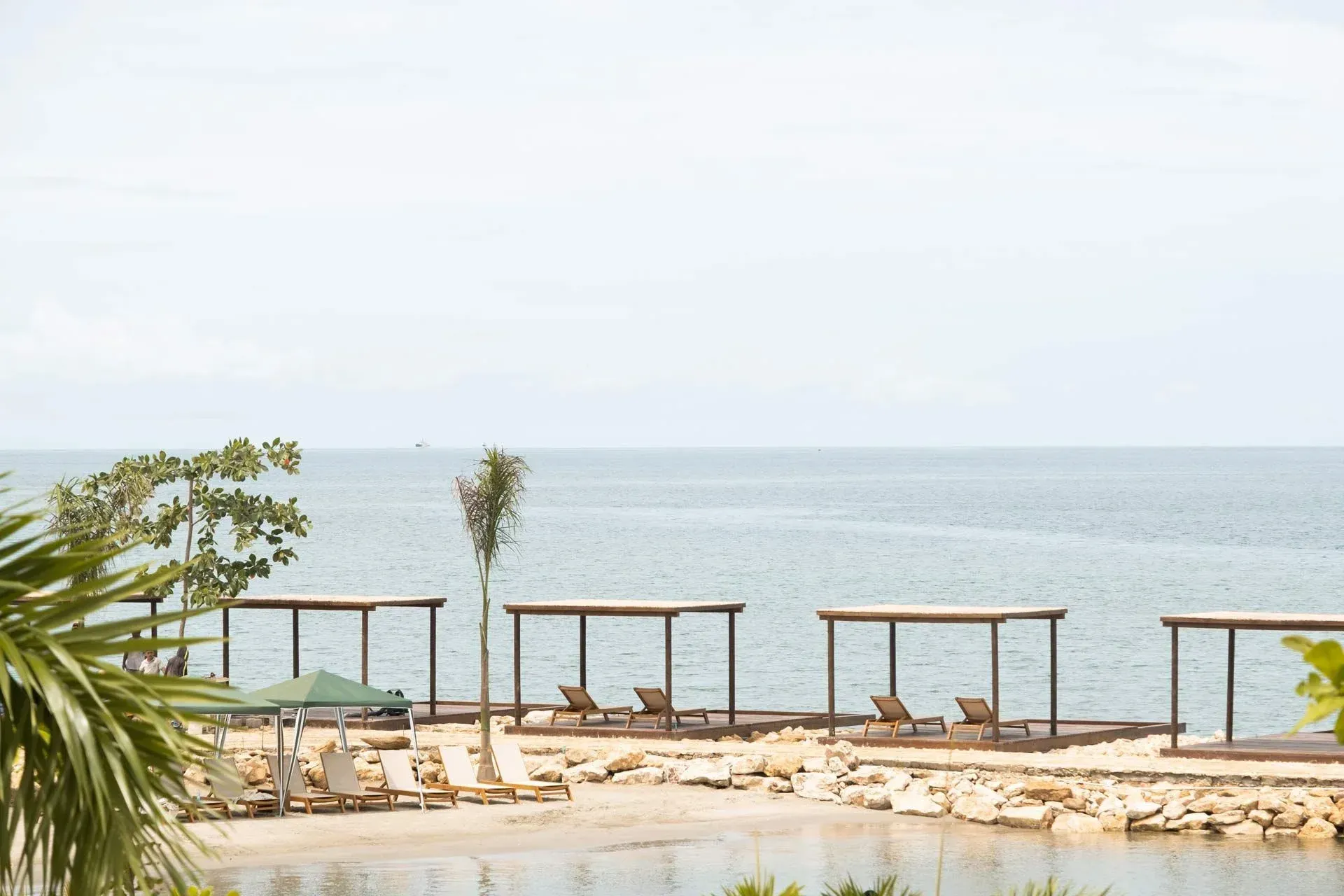 hoteles frente al mar en colombia con asoleadoras, pérgolas de madera, arena clara y vista al mar en Aimarawa.
