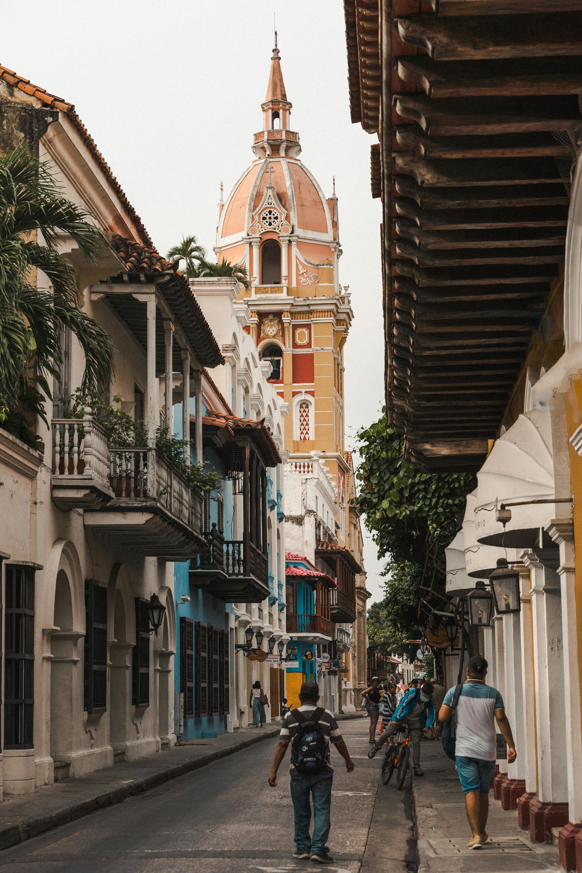 Colonial church tower framed by balconies and colorful façades in the historic town center.
