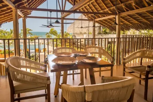Restaurante Guadua del Hotel Aimarawa en San Antero con mesas de madera, sillas artesanales y vista al mar caribe.