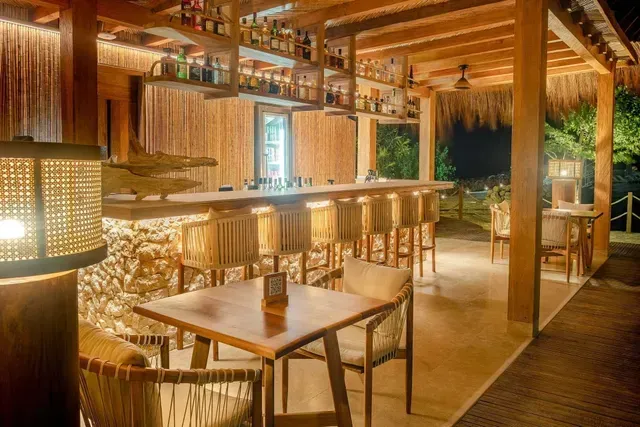 Guadua, restaurante en san antero con bar, barra de madera, sillas altas, licores y luz cálida.