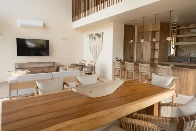 Dining room at Hotel Aimarawa San Antero with wooden furniture, handmade chairs, and garden-view windows.