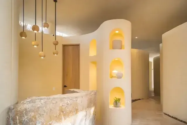 Aimarawa hotel in San Antero with spa, featuring a stone reception desk, curved walls, and illuminated shelves.