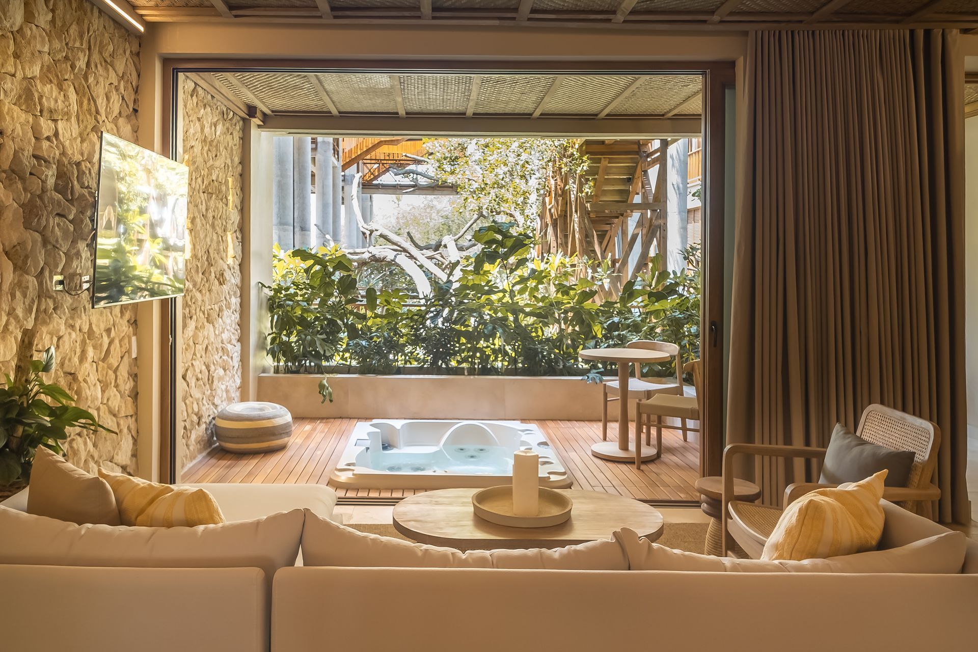 Hotel in San Antero, Colombia, with built-in bathtub, wooden furniture, and views of tropical greenery.