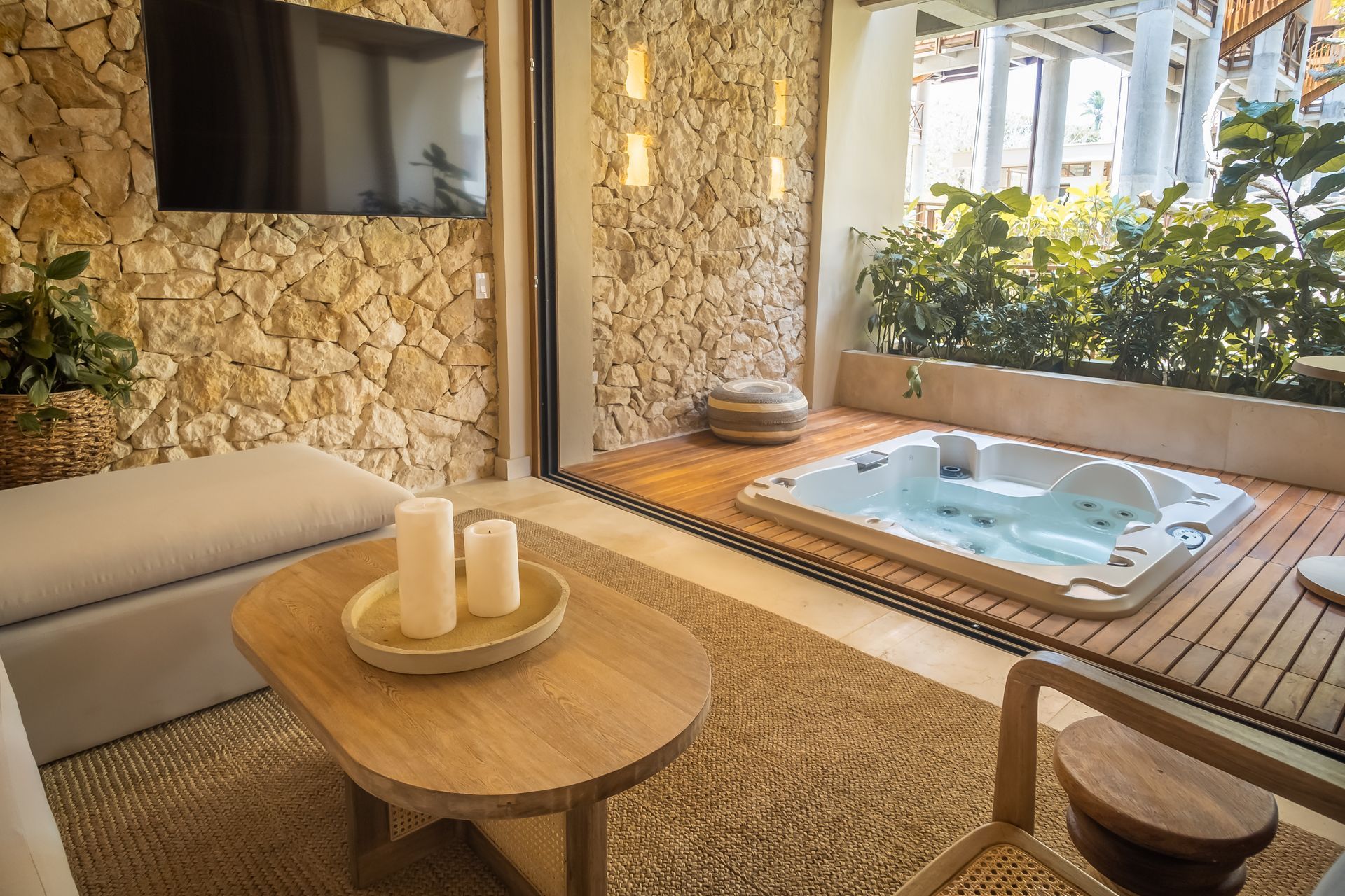 Accommodation in San Antero, Colombia, with built-in tub, side table, sofa, and tropical greenery.