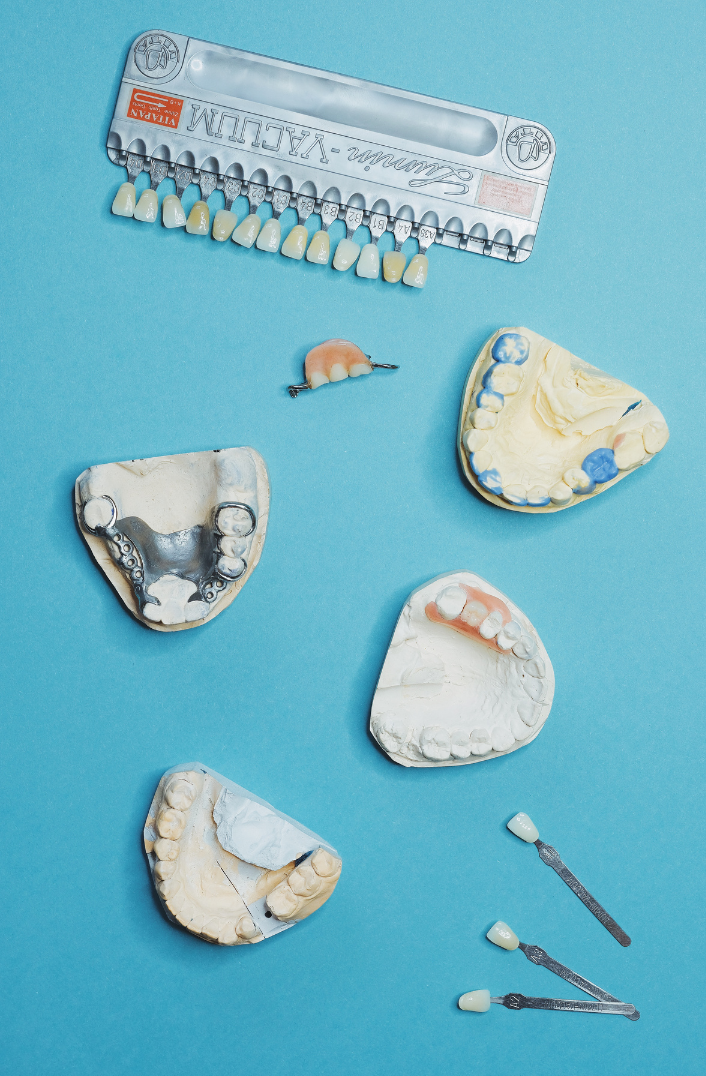 A bunch of dental appliances are laying on a blue surface.