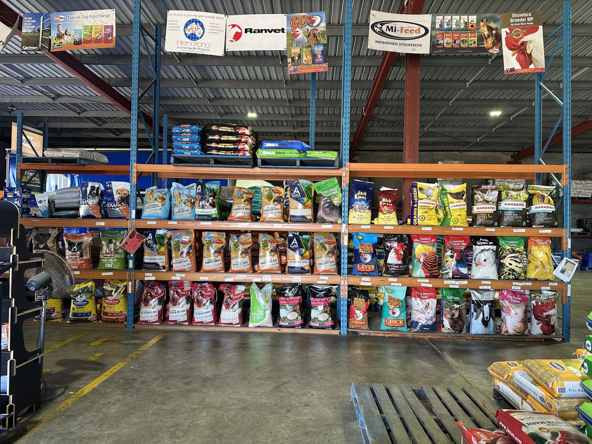 Shelves stocked with various brands of pet food bags in a warehouse setting.https://webbuilder.localsearch.com.au/preview/d9199698