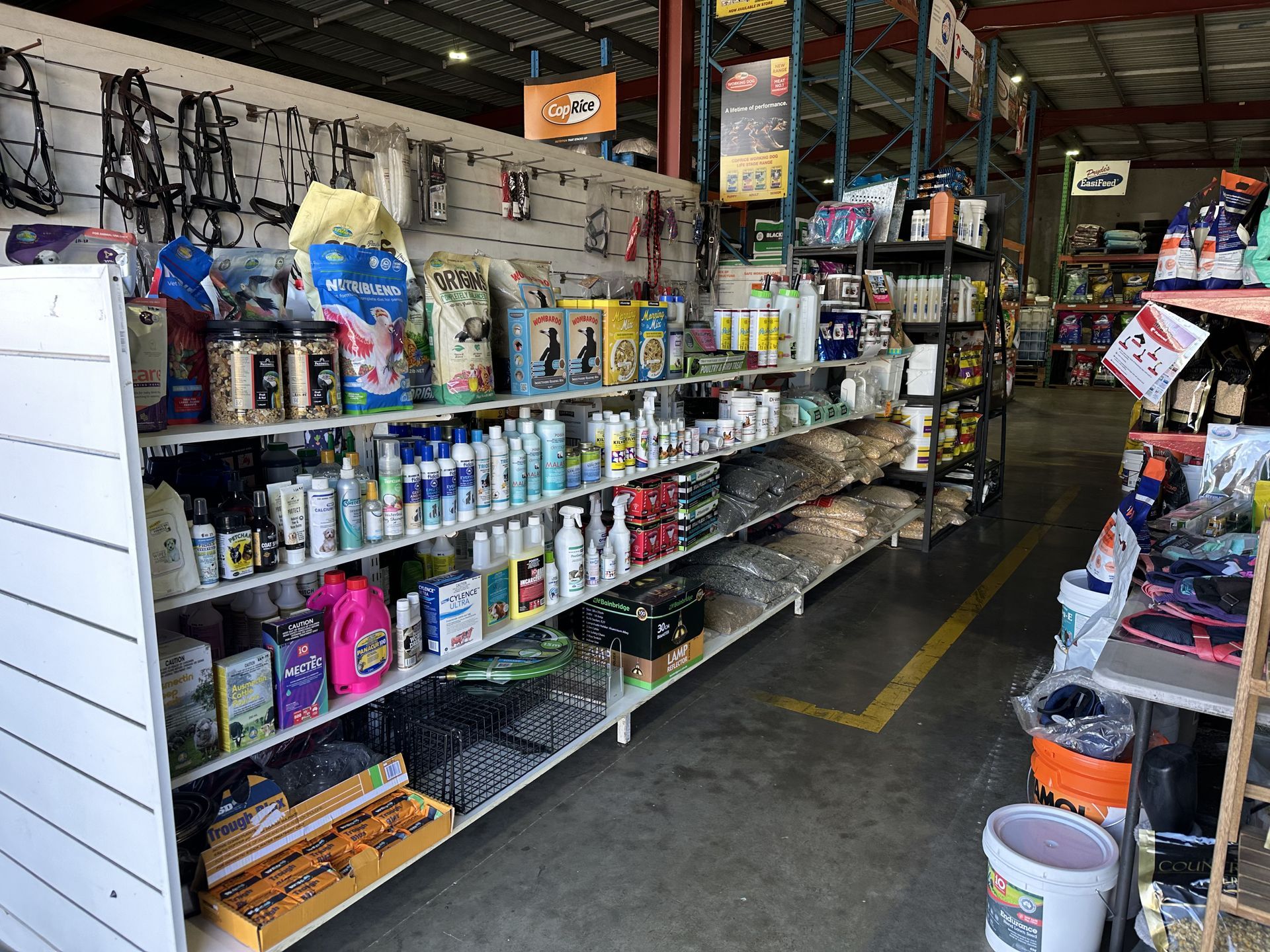 A store interior with shelves of products, including pet supplies and cleaning products. — North Coast Stock Feeds in Wardell, NSW