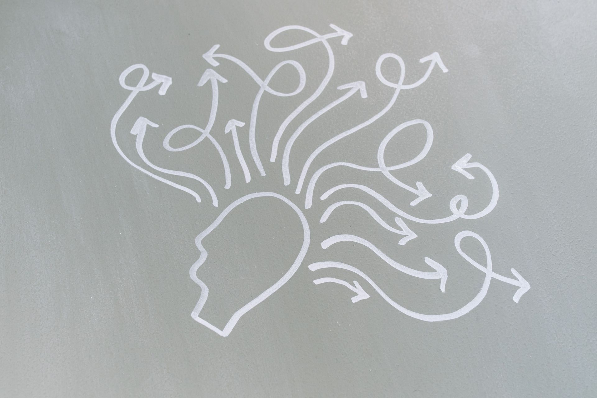 A drawn profile with branching arrows representing different thoughts and possibilities.