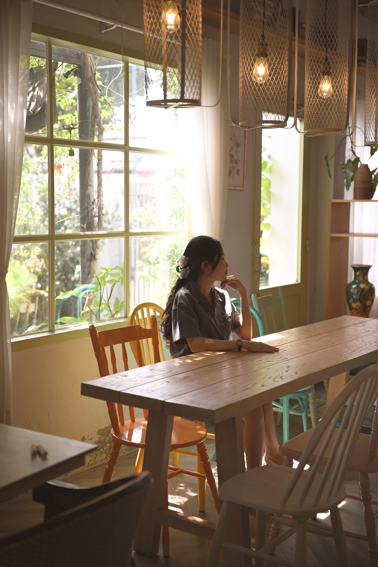 Woman sitting quietly by a sunlit window.