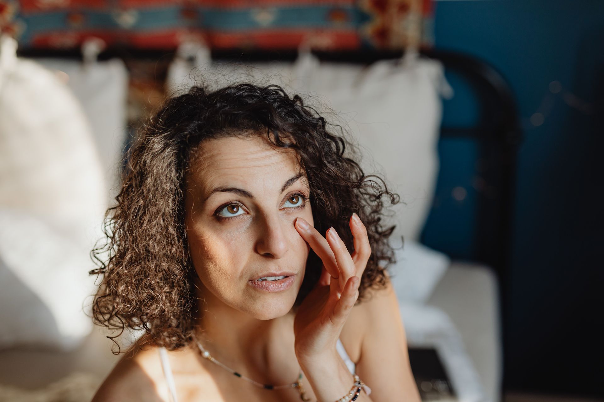 Woman gently touching the skin beneath her eye.