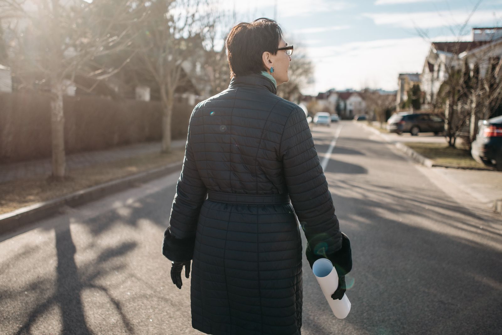 Woman walking along a residential street.