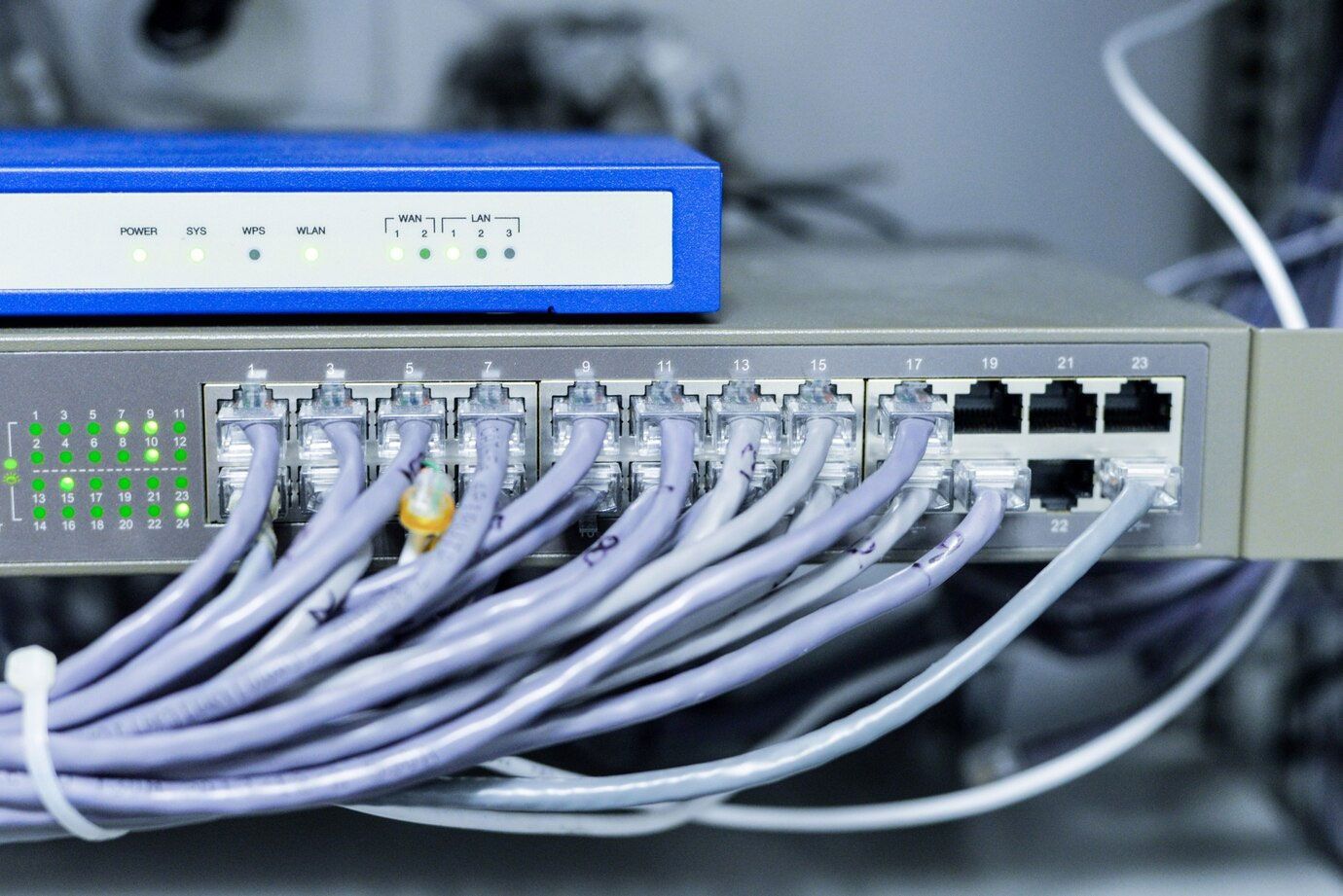 A bunch of wires are connected to a router in a server room.