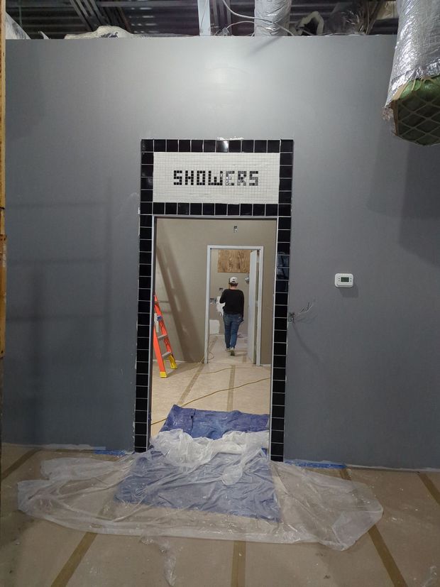 A grey wall with a doorway labeled