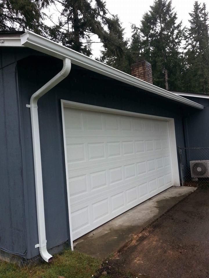 A garage with a white door and a white gutter