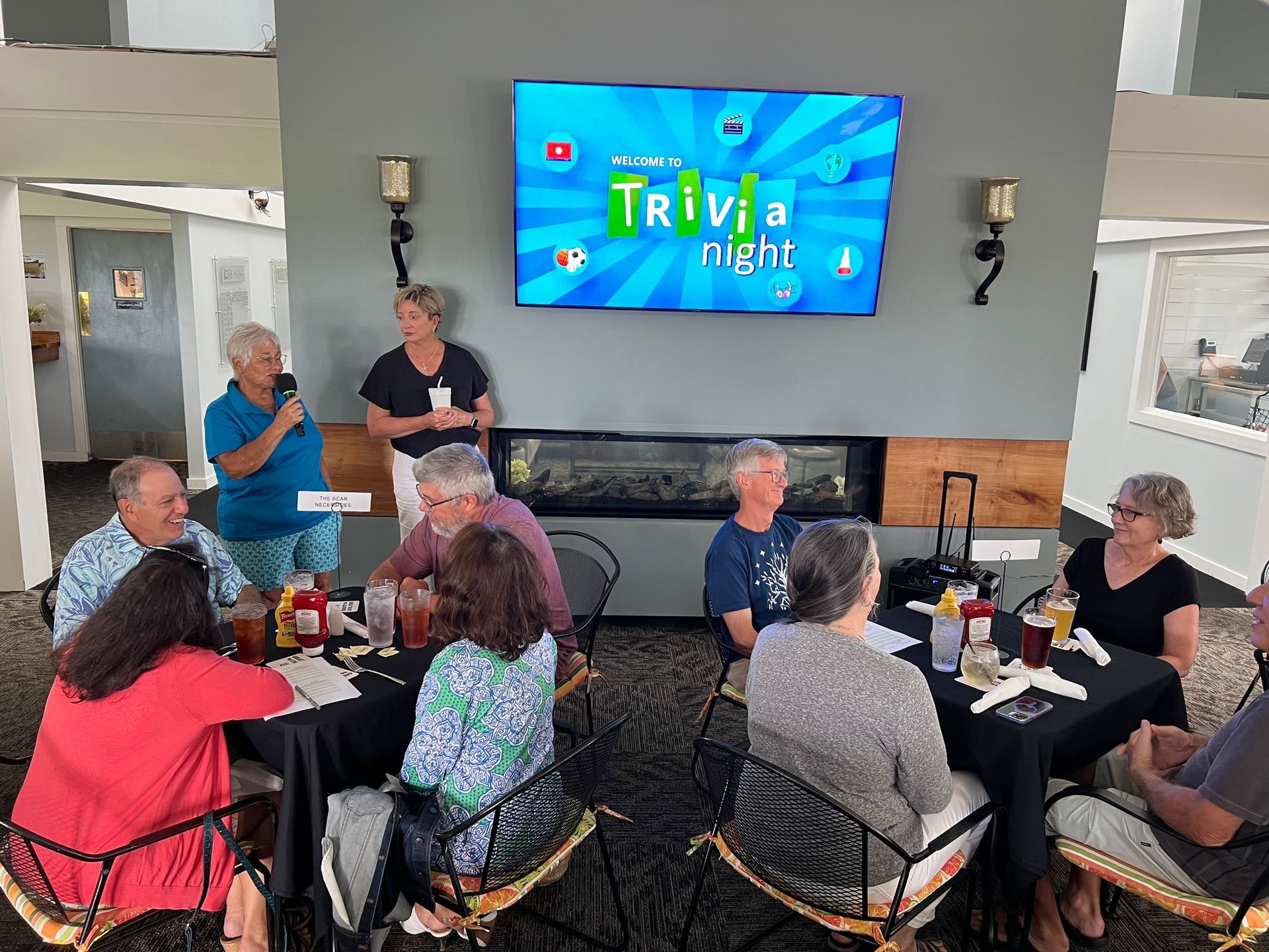 People playing trivia in a restaurant; a screen displays 