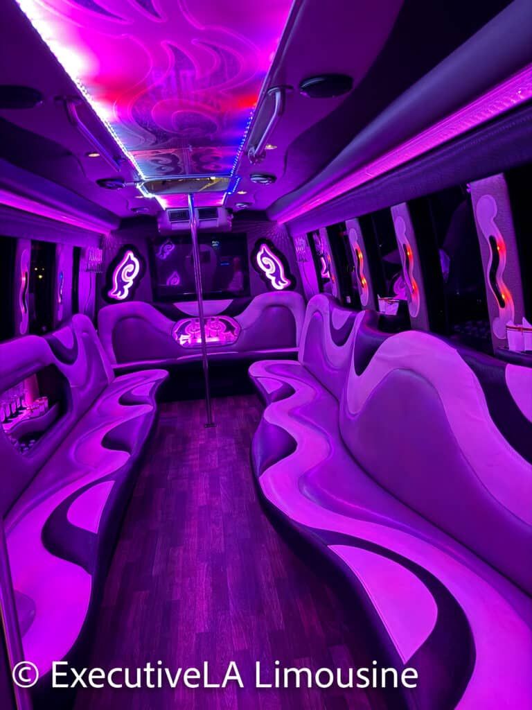 Purple-lit luxury limousine interior with leather seats and wood floor