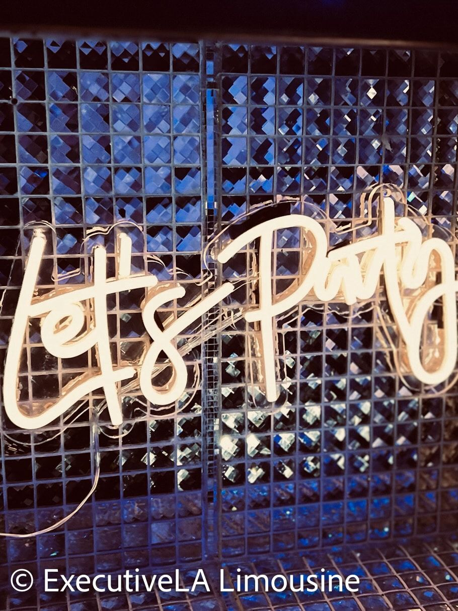 Neon “Let’s Party” sign on a blue tiled wall