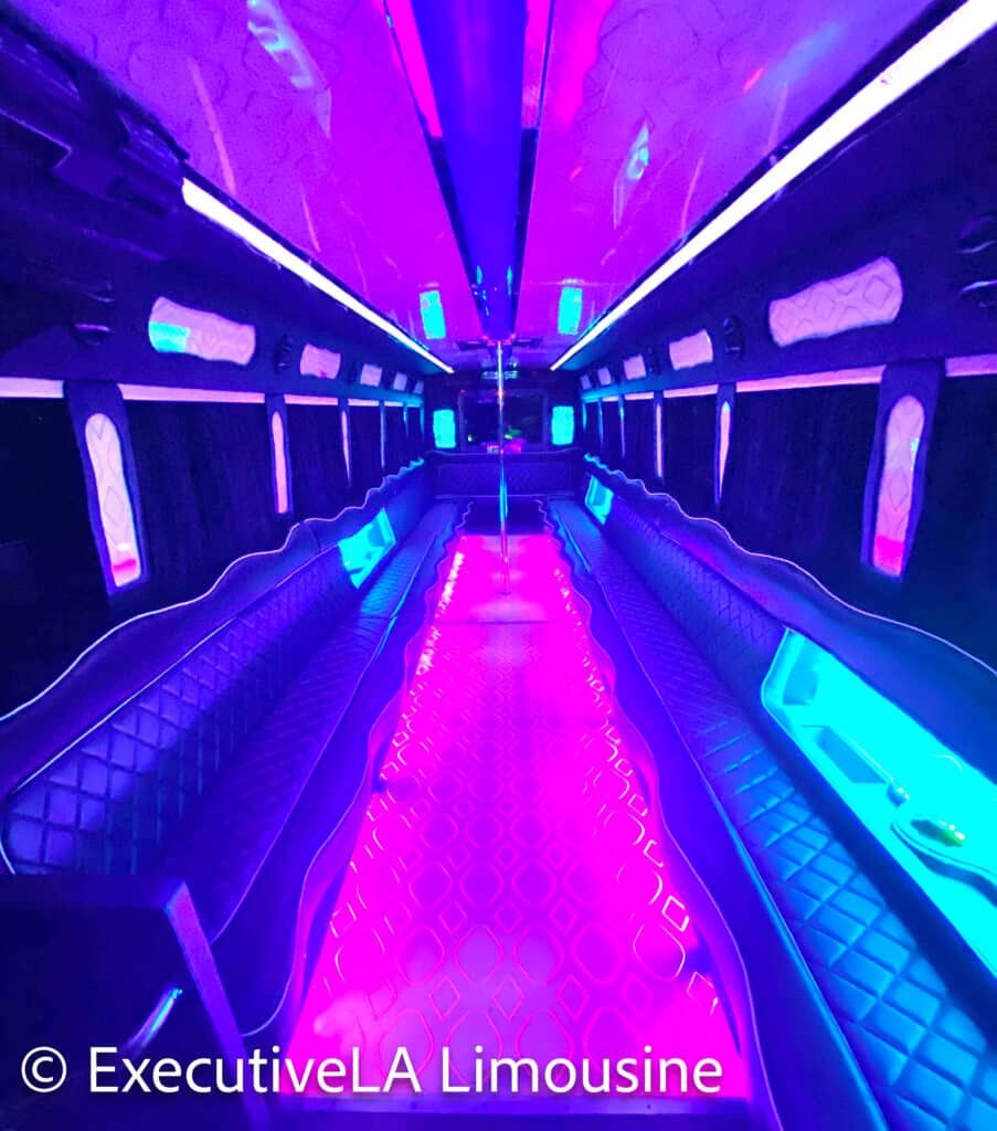 Neon-lit luxury limousine interior with purple and blue LED lights and quilted seating sides