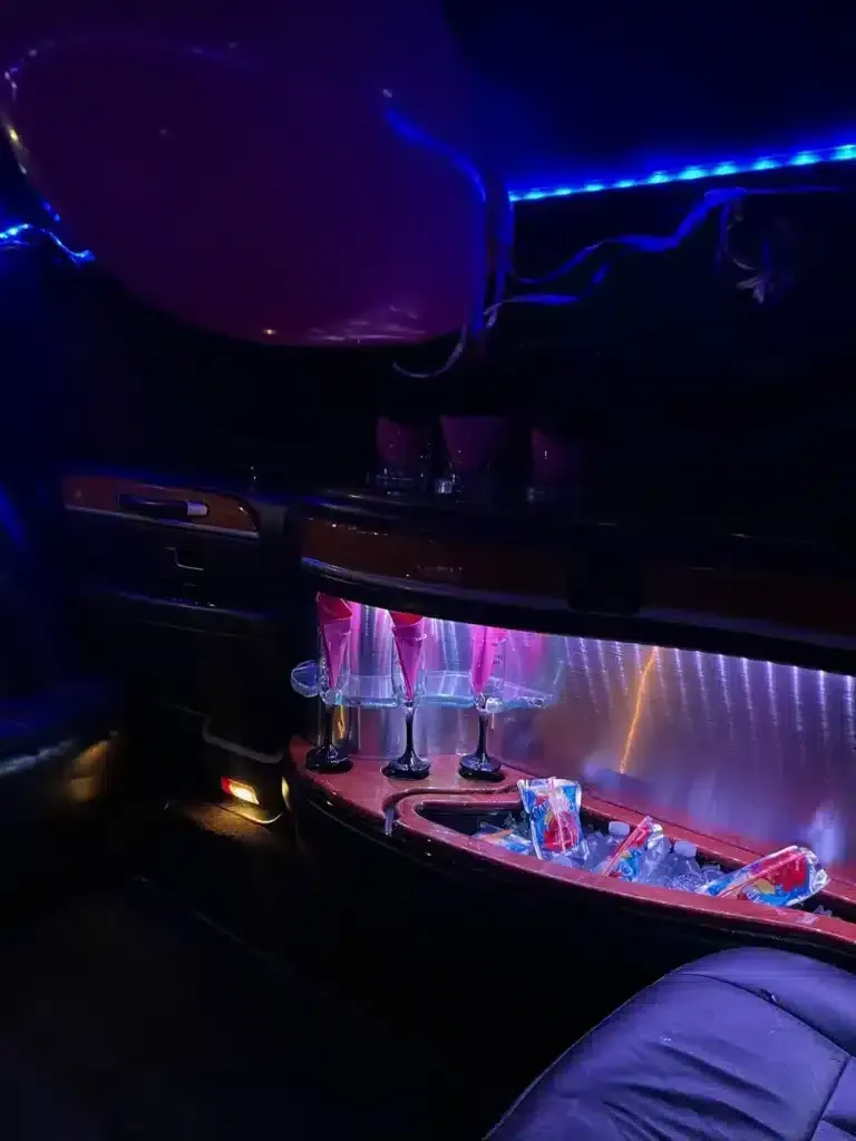 Dim gaming setup with purple-blue LED lights, a desk, monitor, and red-lit keyboard