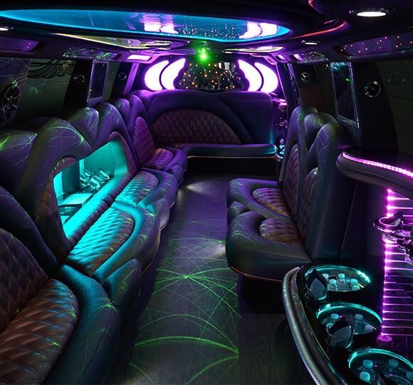 Neon-lit limo interior with leather seating and purple, teal, and green ambient lights