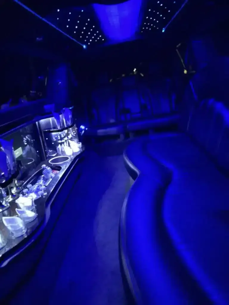 Blue-lit nightclub interior with curved seating and a reflective bar counter