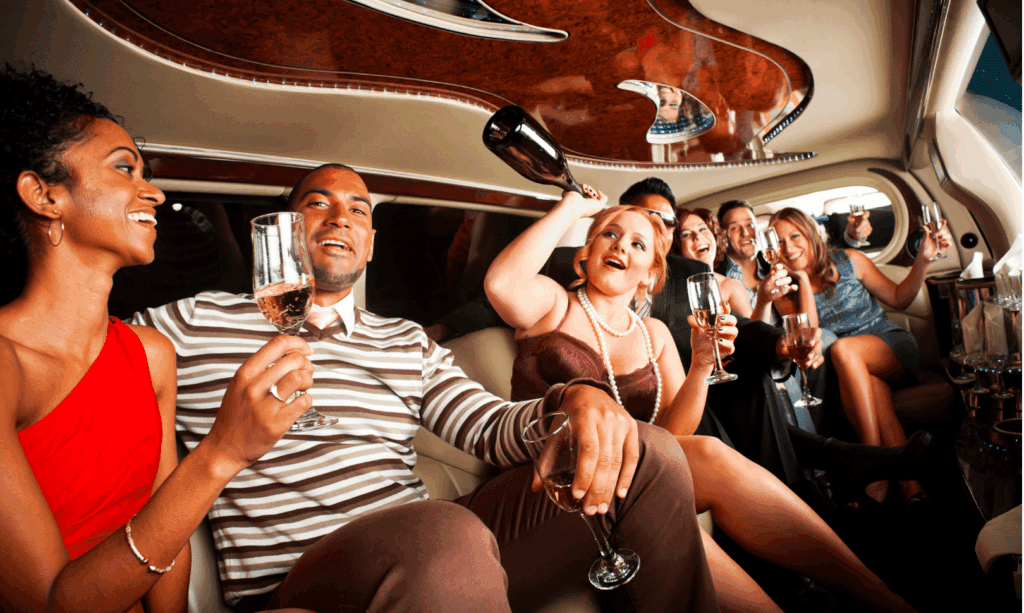 People laughing and chatting in a limousine interior with red and silver accents