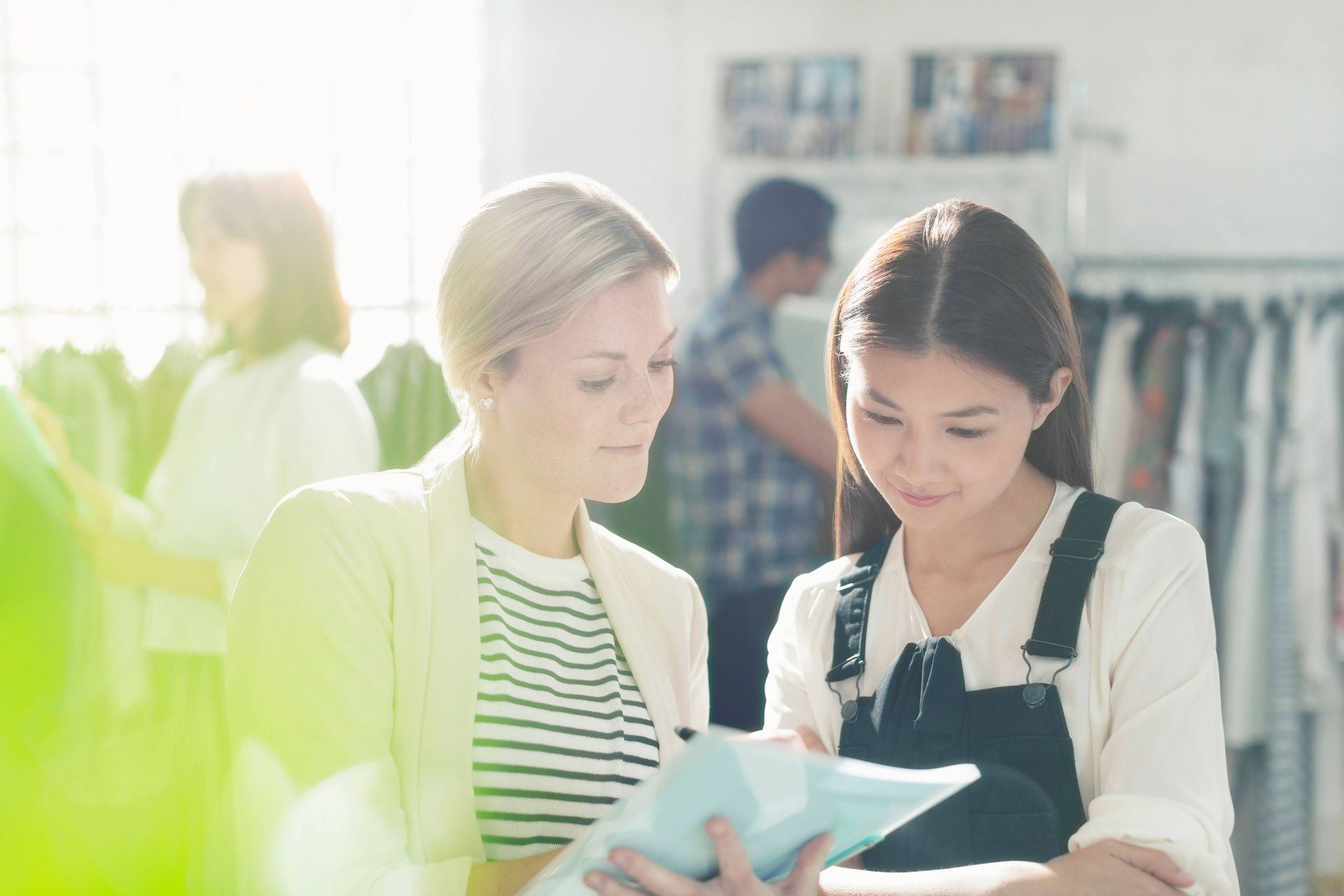Two people reviewing a document in a bright clothing store