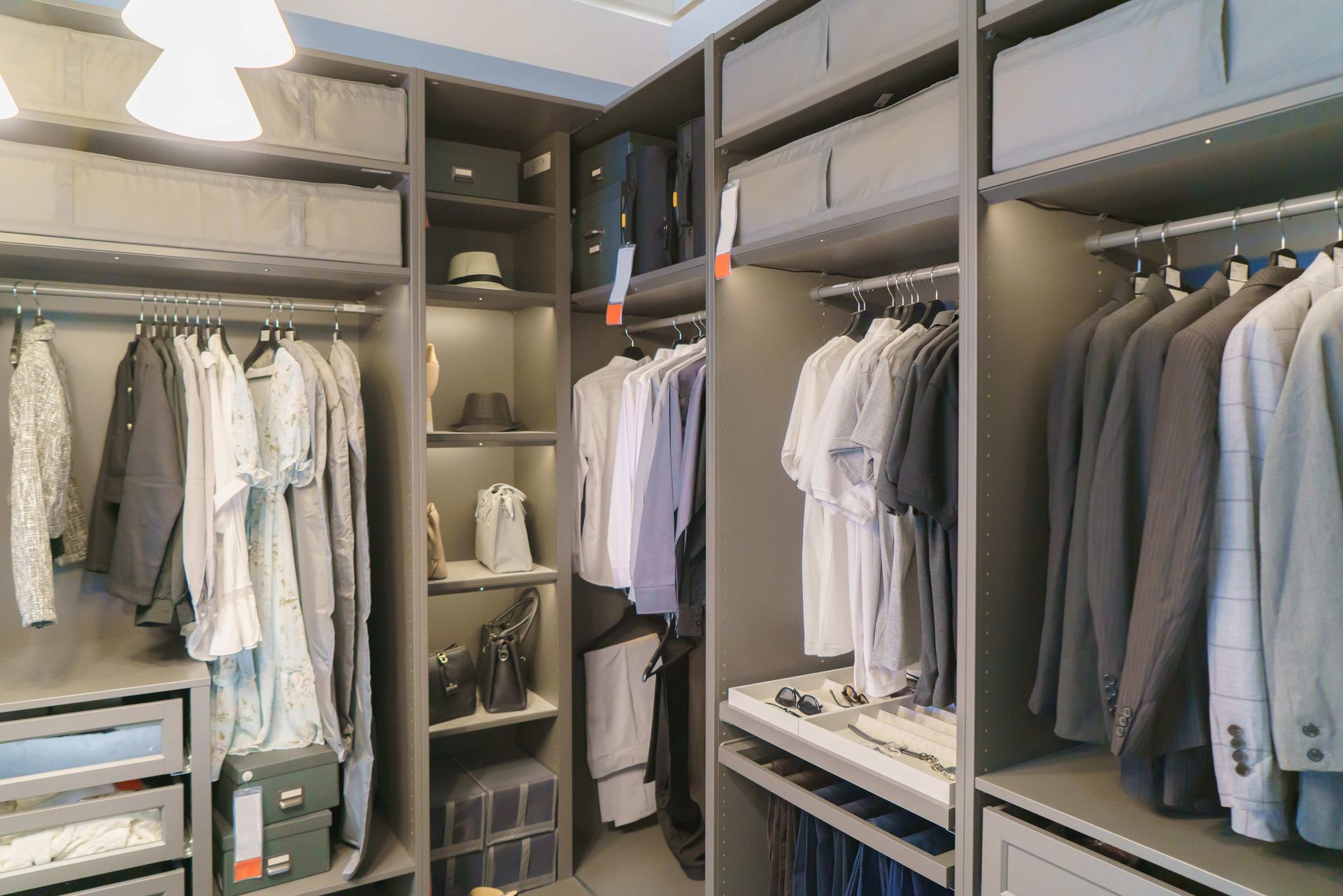 Walk-in closet with hanging clothes, shelves, and folded garments in a neutral-toned room
