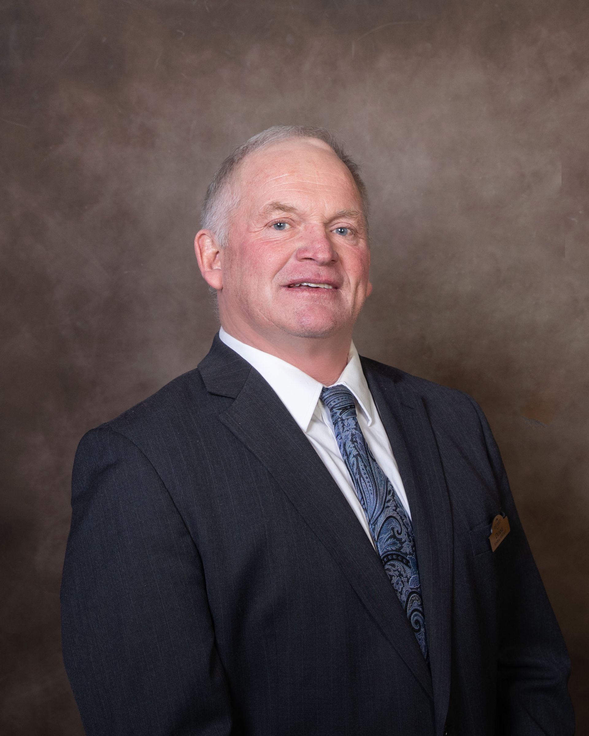 A man in a suit and tie is smiling for the camera.