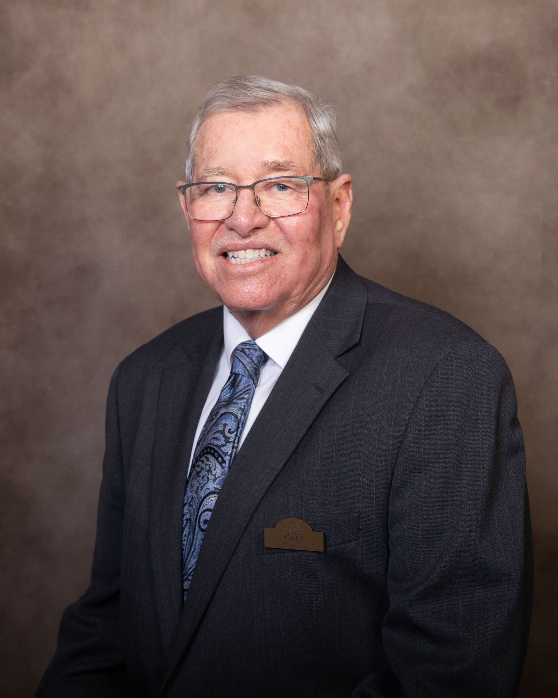 A man in a suit and tie is smiling for the camera.
