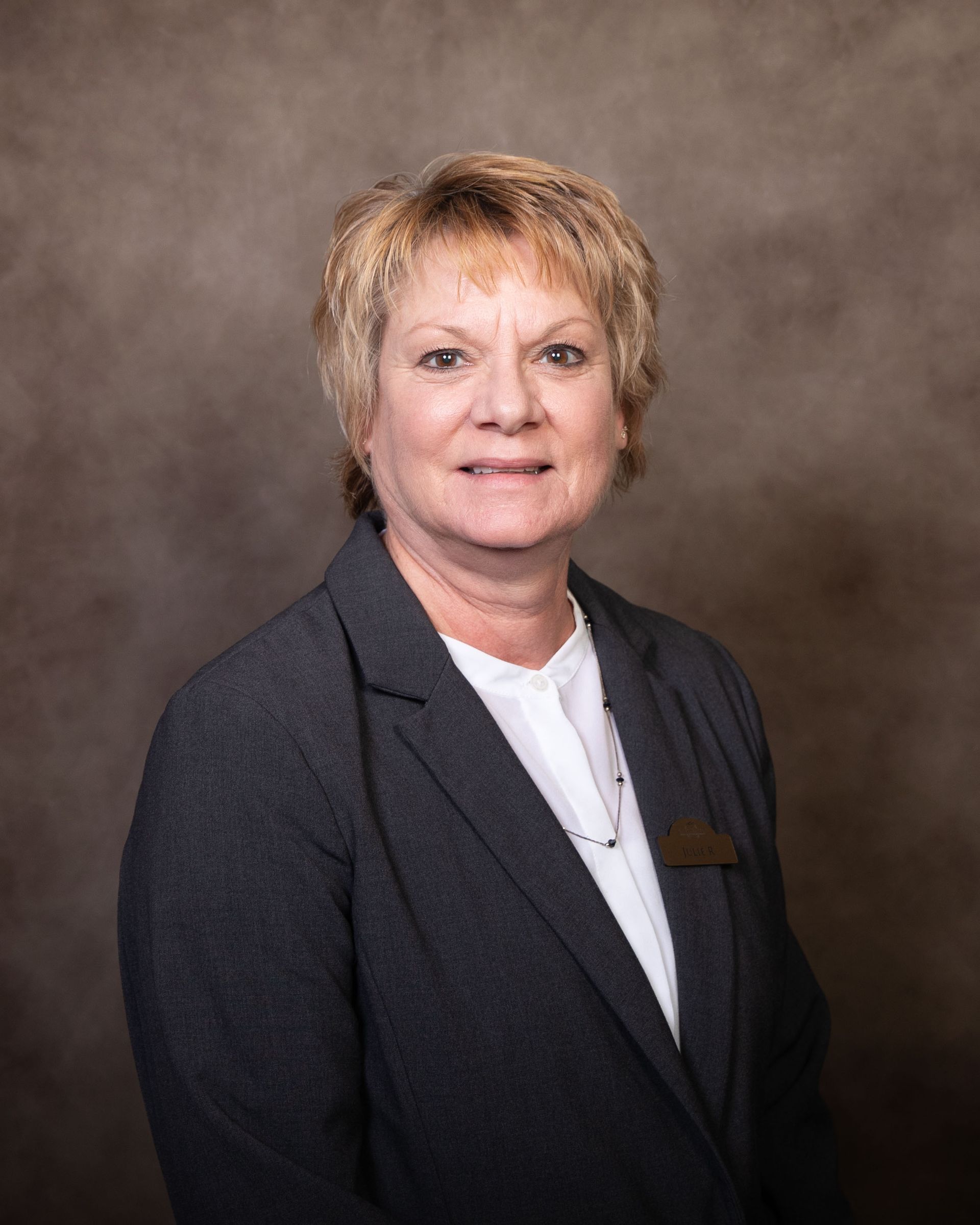 A woman in a suit and white shirt is posing for a picture.