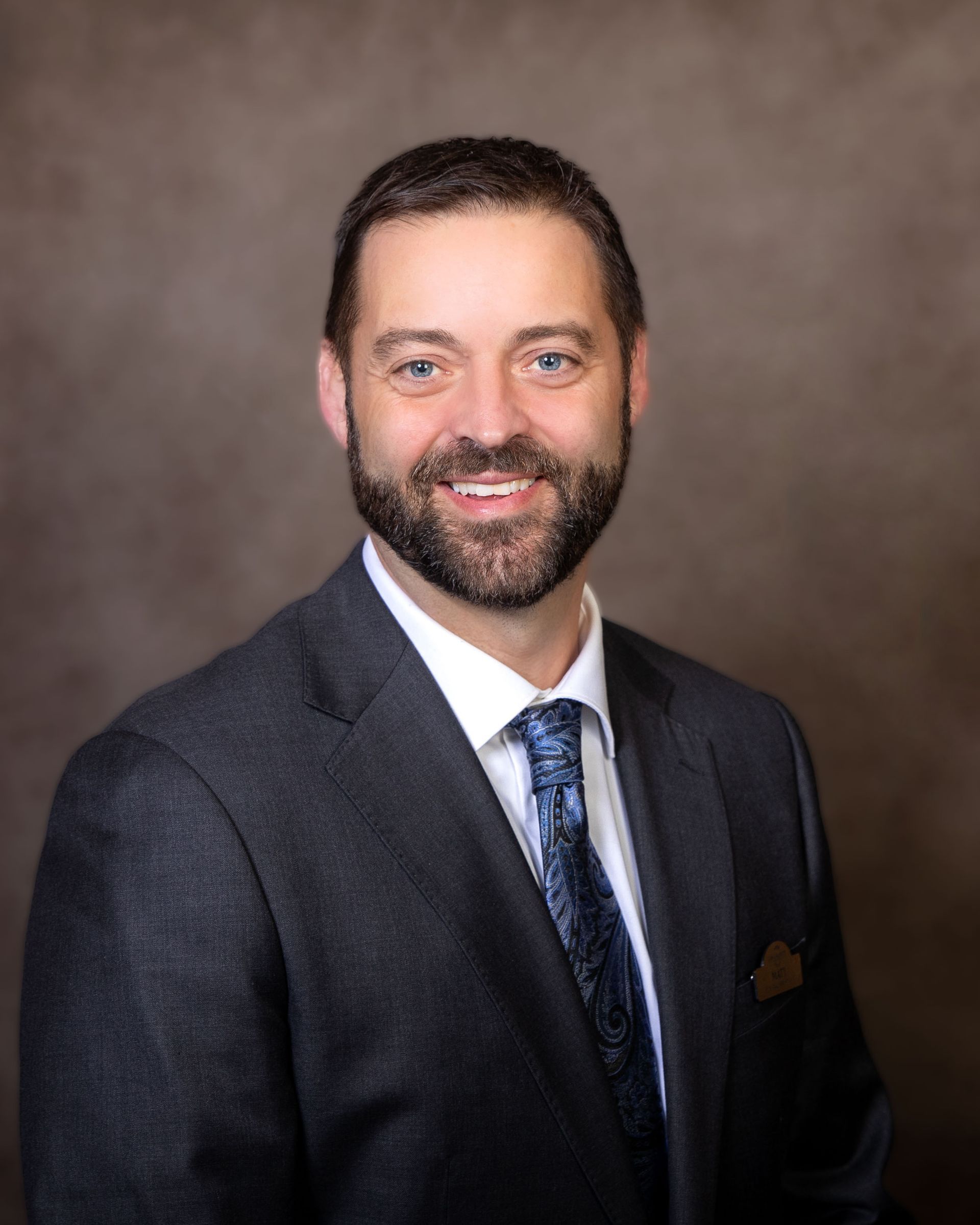 A man in a suit and tie is smiling for the camera.